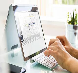 Bildschirm mit WEBPROJECT-Screen, Tastatur, Hand bedient die Software