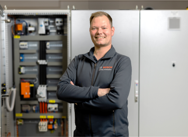 Bosch-Mitarbeiter steht vor einem DIGICONTROL-Schaltschrank